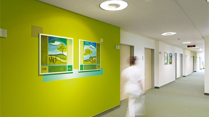 Pielęgniarka idąca korytarzem kliniki psychiatrii; oświetlenie marki Philips