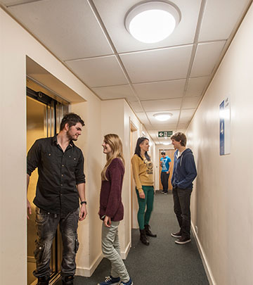 Studenci na korytarzu w akademiku należącym do firmy Unite