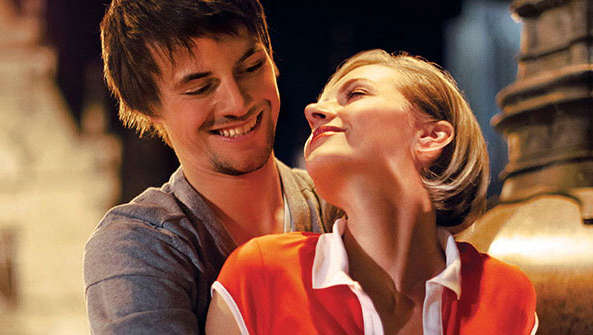 Szczęśliwa para przytula się na placu w promieniach światła Philips