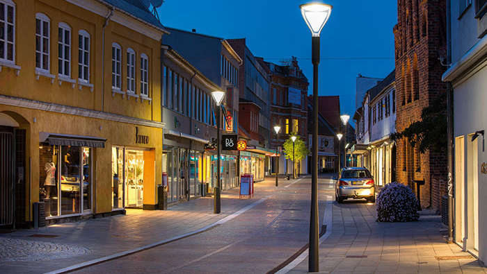 Ulica pełna sklepów w promieniach oświetlenia marki Philips Lighting