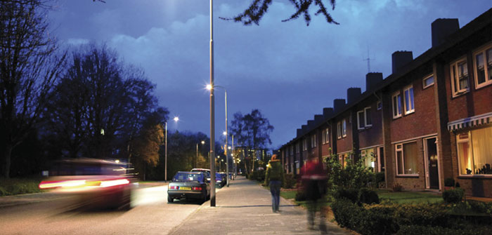 Samochody na ulicy efektywnie oświetlonej białym światłem Philips