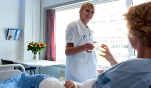 Pielęgniarka oferuje szklankę wody pacjentowi