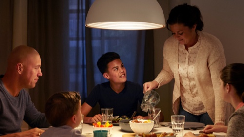 Rodzina jedząca obiad w domu przy dobrze oświetlonym stole