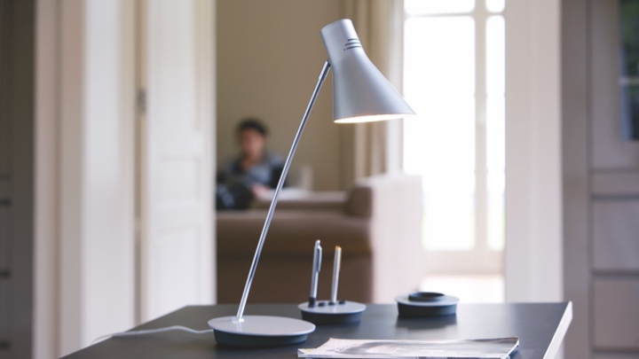 Lampa stołowa na biurku skierowana na papier i długopis