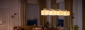 Nowoczesna lampa wisząca LED z wieloma kloszami z tkaniny rozświetla przytulny salon, prezentując energooszczędne i stylowe rozwiązania oświetleniowe, zapewniające wieczorny komfort w domu.